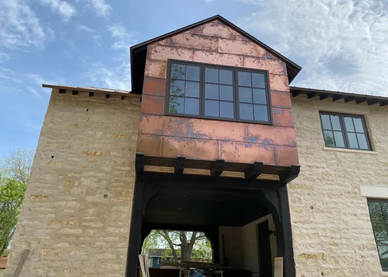 Copper metal panel facade on a stone building for Roof Repair in Berryville